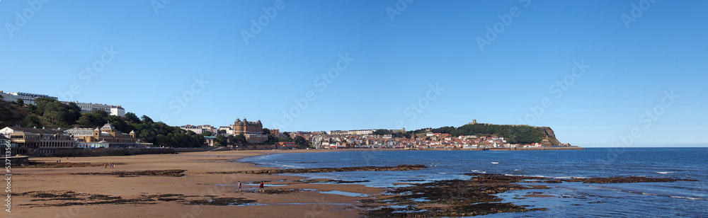 Long panoramic view of town of Scarborough from the beach on the south bay in summer sunlight