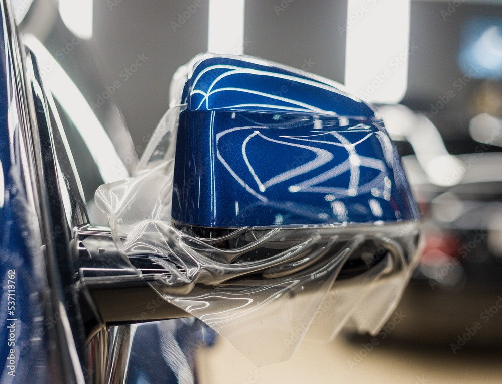 The process of installing PPF on the side mirror. PPF is a protective