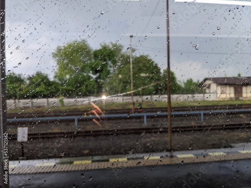 The landscape photo of rail train with field view. The photo take inside the train when rainy water drop. The photo is suitable to use for nature background, transportation back ground and advertsing. photo