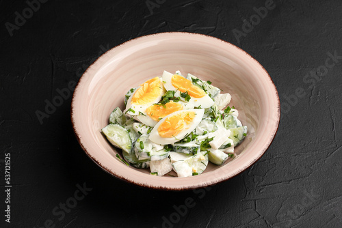 Salad with cucumbers, fresh salad with cucumbers and eggs on a black background