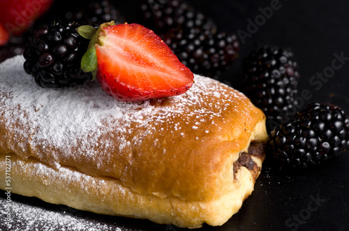 Macro of Strawberry and Blackberries on Chocolate Pastry with Powdered Sugar