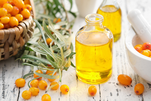 Obraz na plátně Bottles of sea buckthorn essential oil, mortar and basket of sandthorn berries