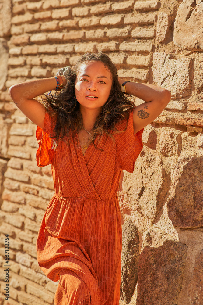 African American girl with orange dress smiling posing in Toledo,Spain