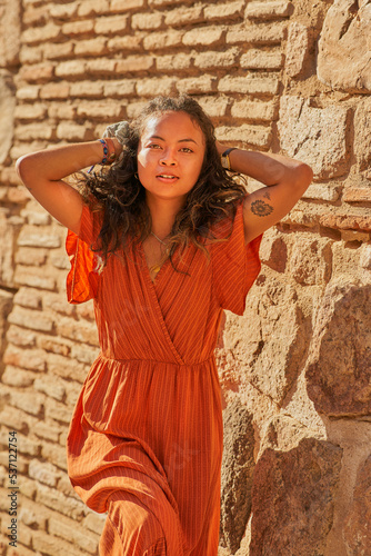 African American girl with orange dress smiling posing in Toledo,Spain