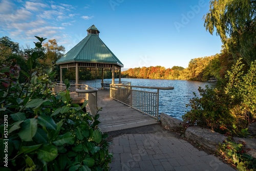 Fototapeta Naklejka Na Ścianę i Meble -  A gazebo park structure in autumn at Mill Pond in Centennial Park, Milton, Ontario, Canada