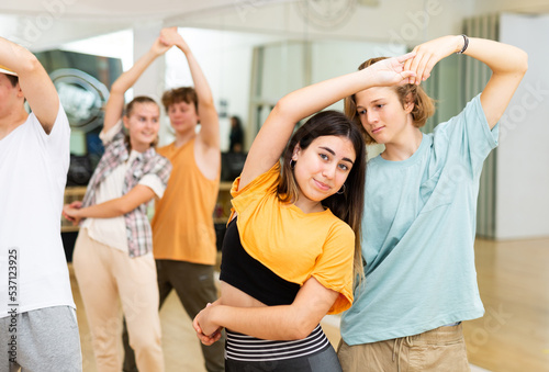Positive teenagers dancing together slow ballroom dances in pairs in choreography class . © JackF