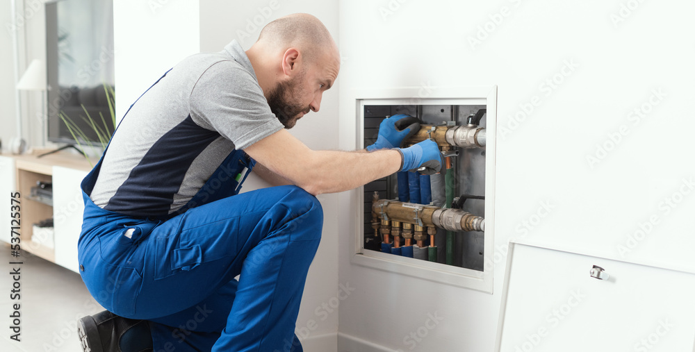 Professional plumber installing plumbing manifolds