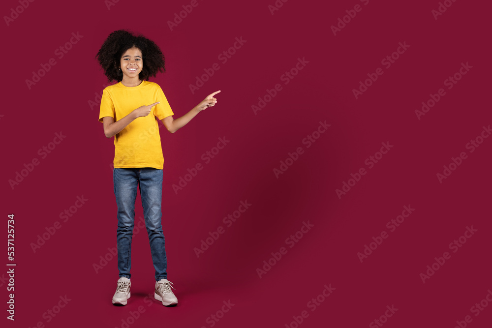 Stylish african american preteen girl pointing at empty space