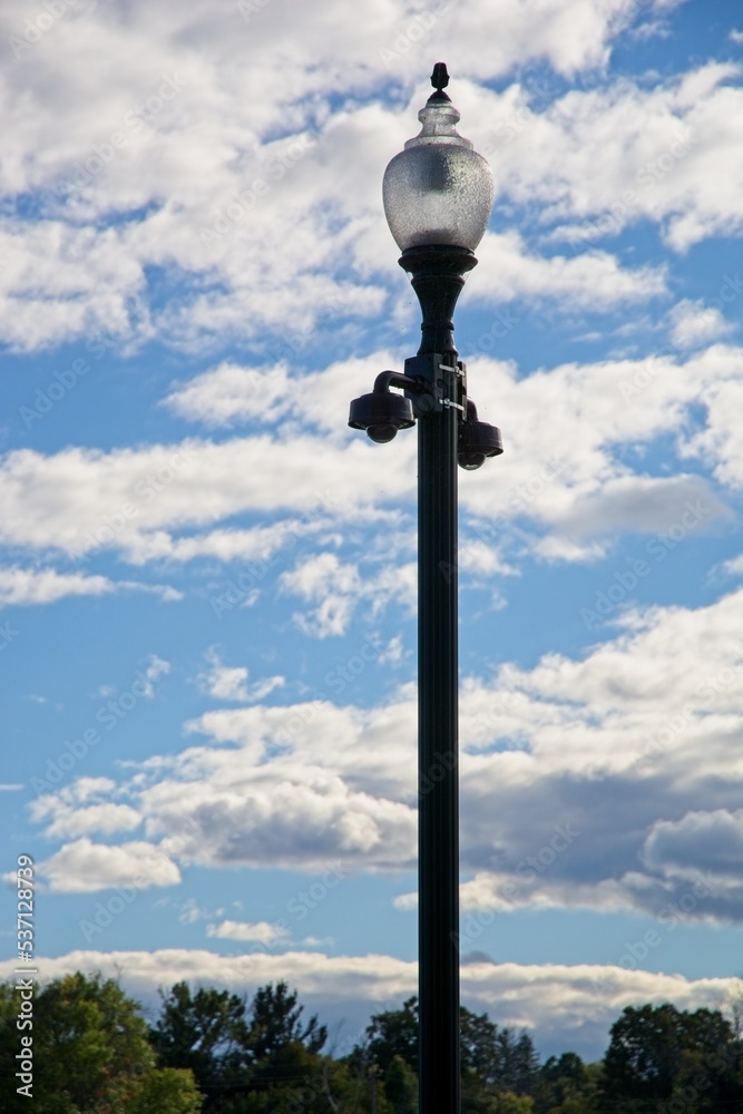 Street lamp before bright cumulus clouds