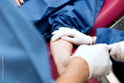 medical procedure  the doctor takes blood from the patient s vein  close-up