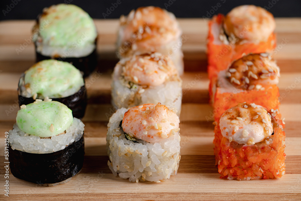 Set of sushi rolls on bamboo serving tray. Uramaki and futomaki roll Set of sushi rolls on bamboo serving tray. Uramaki and futomaki roll