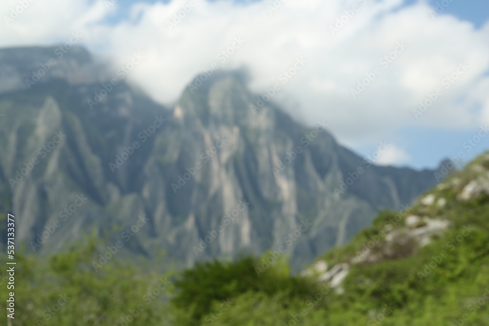 Beautiful mountains and plants near road under cloudy sky, blurred view Beautiful mountains and plants near road under cloudy sky, blurred view