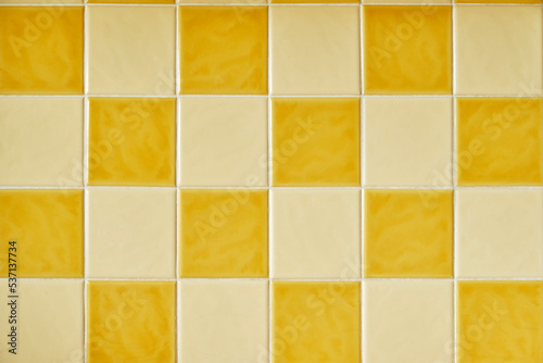 Original 1970s retro wall tiles. Square orange and yellow checkered tiles. Vintage style home decor. Colorful retro wall tiles with white grout