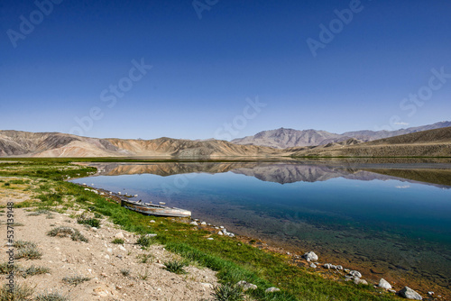Reflecting rainbow mountains on Lake Bulunkul, Pamir Highway, Tajikistan