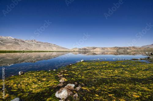 Reflecting rainbow mountains on Lake Bulunkul, Pamir Highway, Tajikistan photo