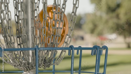 Close up of Disc Golf Frisbee Putt hitting metal basket in slow motion photo