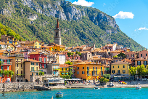 Fototapeta Naklejka Na Ścianę i Meble -  The colorful Italian lakefront village of Varenna, Italy, with tourists enjoying the cafes and shops along the waterfront on Lake Como. 