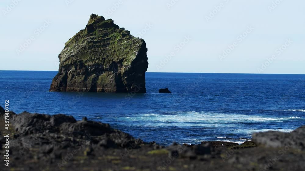 Lonely rock in the middle of the blue ocean, nature landscape in Iceland, lone concept Lonely rock in the middle of the blue ocean, nature landscape in Iceland, lone concept