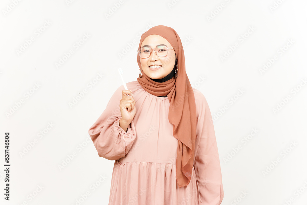 Holding toothbrush and smiling to camera of Beautiful Asian Woman Wearing Hijab Isolated On White Holding toothbrush and smiling to camera of Beautiful Asian Woman Wearing Hijab Isolated On White