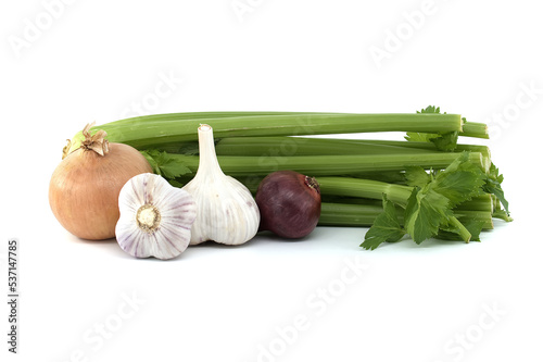 Onion and garlic bulbs in front of celery