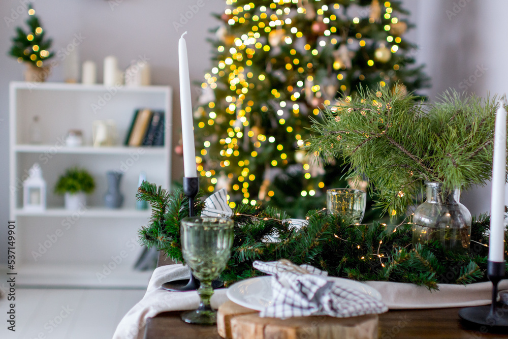 A festive Christmas table set with fir branches and lights