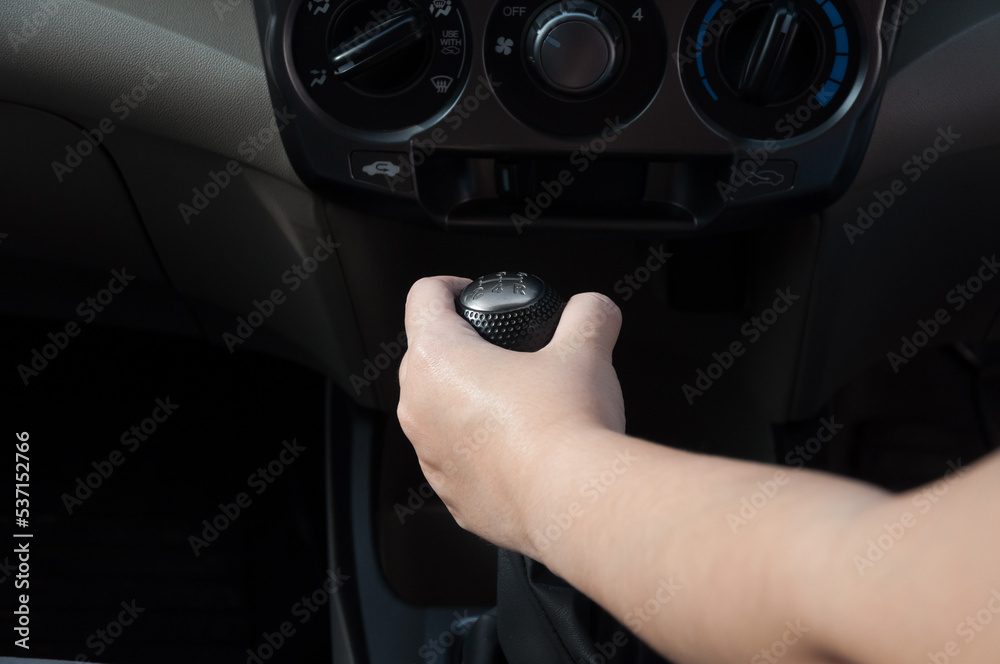 Driver hand shifting the gear stick,Hand on car gear knob.The driver switches the speed in the car. Hand on gear lever.