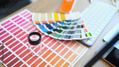 Fan and set of colourful samples and loupe on table photo