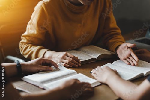 Fotografia, Obraz Christian couple or group reading study the bible together and pray at a home or Sunday school at church