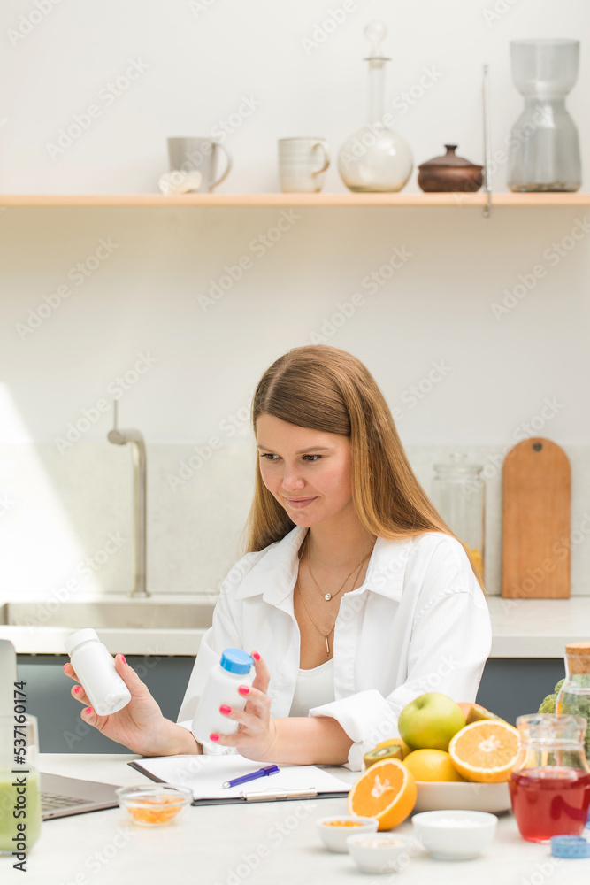 A nutritionist advises a client at an online appointment on a schedule for taking vitamins and dietary supplements. A nutritionist advises a client at an online appointment on a schedule for taking vitamins and dietary supplements.