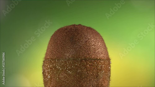 Half Kiwi falling and splashing on white background. Food levitation concept. Slow Motion photo