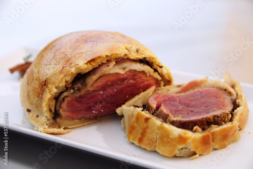 Classical Beef Wellington on a white plate. Side view