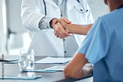 Doctor handshake, congratulations and nurse at office desk consulting on medical procedure, diagnosis or medical health care contract. Thank you, well done or welcome to the hospital cardiology team