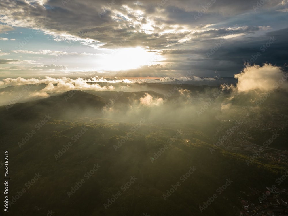 Aerial view of colorful foggy sunset over Resita city, Romania. Captured from a drone.
