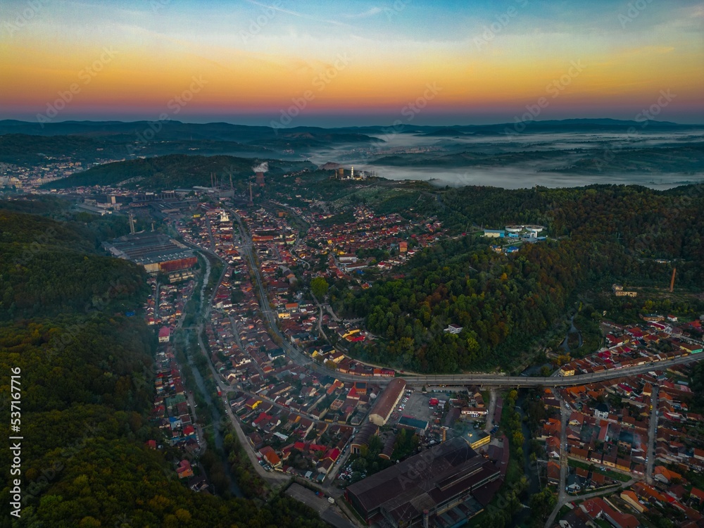 Aerial view of a colorful autumn sunrise in a hilly area near Resita city, Romania. Captured with a drone.