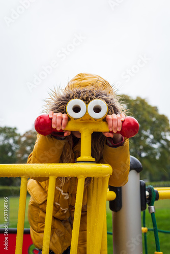 Fototapeta Naklejka Na Ścianę i Meble -  A child playing in a playground on a rainy day