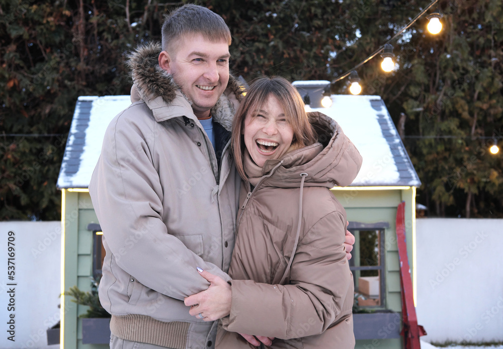 Couple in love, husband and wife hugging and laughing, having fun outdoors in winter Couple in love, husband and wife hugging and laughing, having fun outdoors in winter
