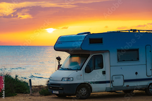 Camper vehicle camp on beach at sunrise