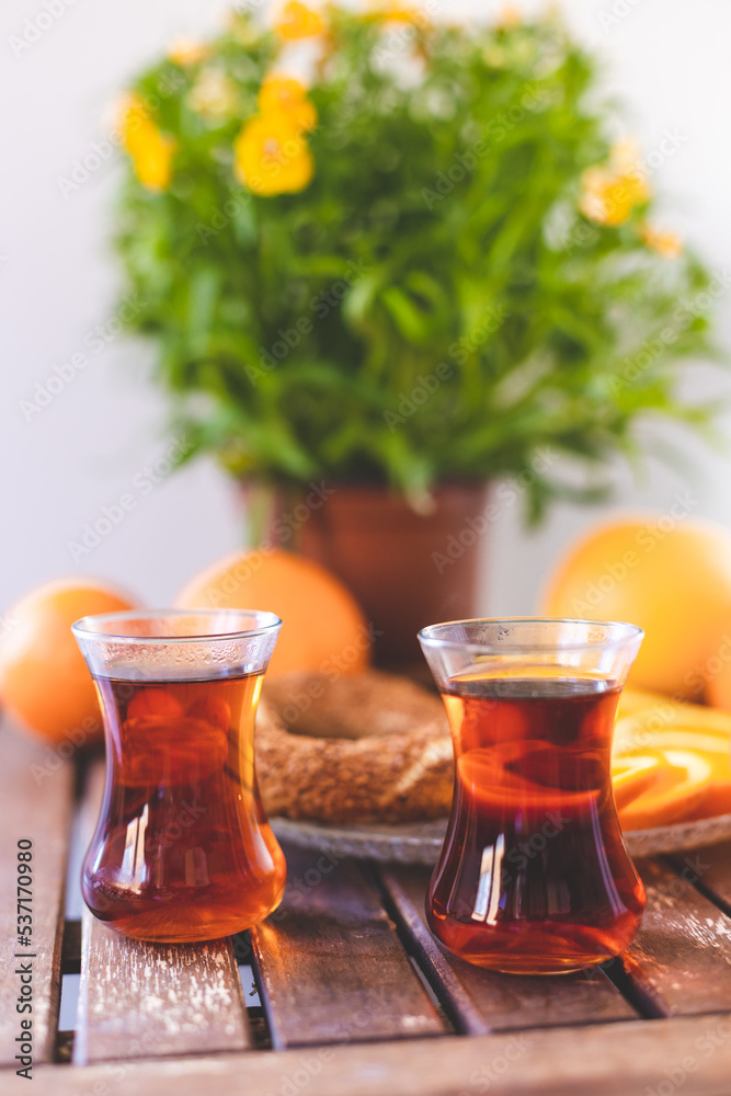 Turkish tea, sesame bagel and oranges on wooden table