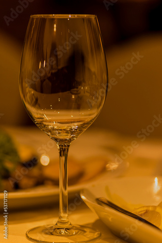 Kieliszek do wina stojący na zastawionym stole , podczas uroczystego przyjęcia .