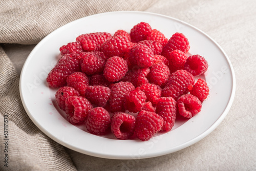 Plate with big yummy ripe organic raspberries Fresh summer berrys.