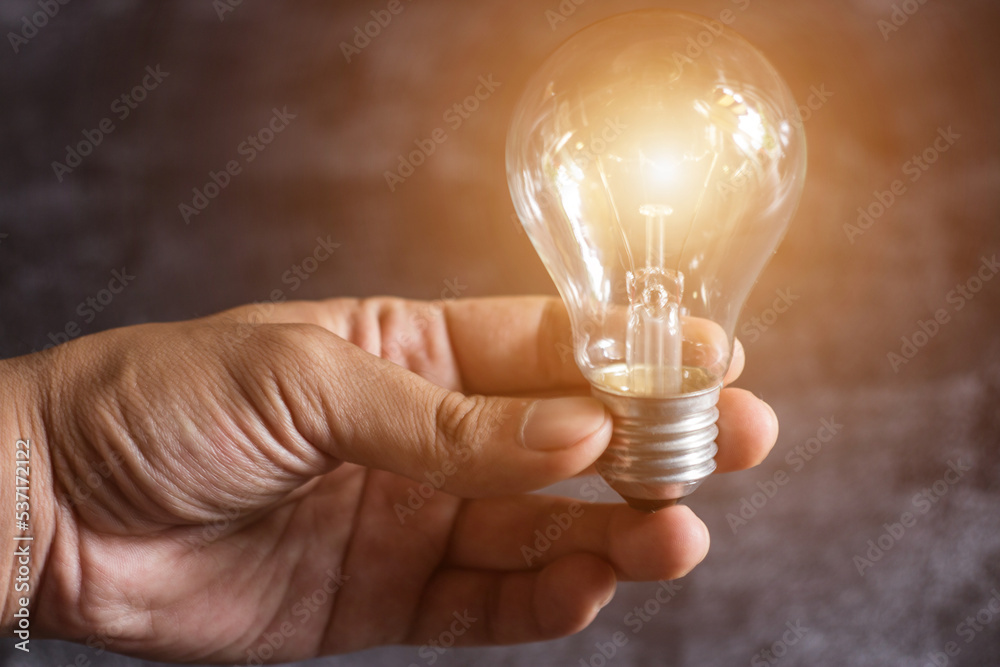Hand of man holding illuminated light bulb, idea, concept creativity with bulbs that shine glitter.
Hand of man holding illuminated light bulb, idea, concept creativity with bulbs that shine glitter.