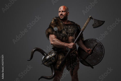 Shot of handsome warrior from north with horned helmet dressed in fur and armor.