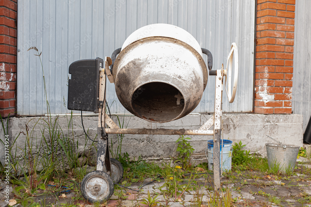 Small concrete mixer after work in the yard of the house Small concrete mixer after work in the yard of the house
