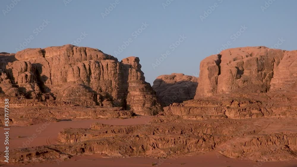 Jordan. Sunrise in the desert. Beautiful panorama of the Wadi Rum desert. The Valley of the Moon is a famous place among tourists. Concept of loneliness, peace, tranquility, remoteness Jordan. Sunrise in the desert. Beautiful panorama of the Wadi Rum desert. The Valley of the Moon is a famous place among tourists. Concept of loneliness, peace, tranquility, remoteness