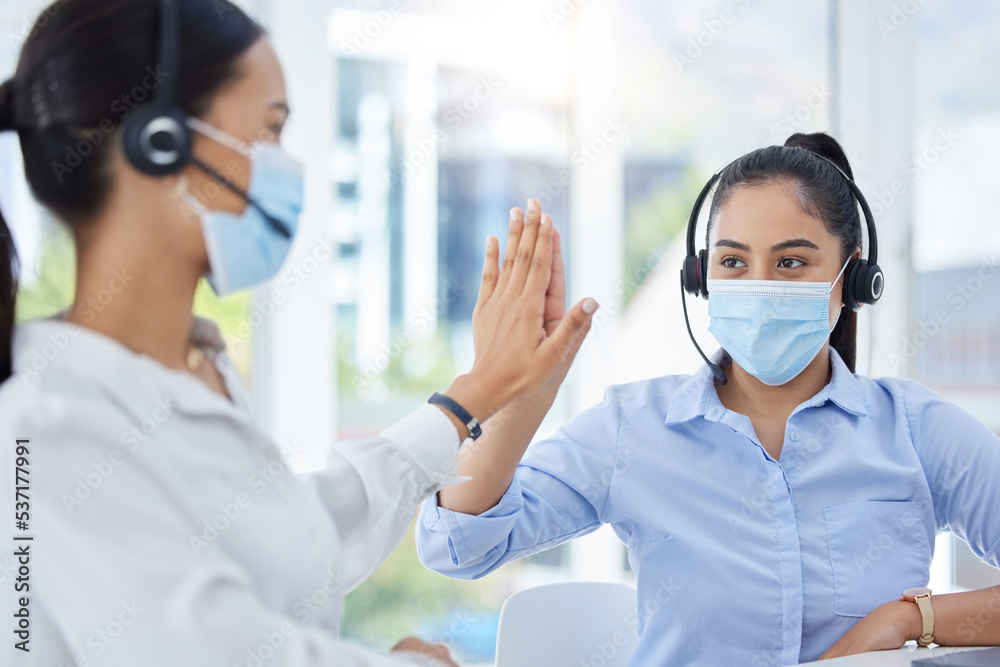 Covid, high five and women in call center with face mask for office compliance, target success or goal achievement. Sales, telemarketing or e commerce business people hands teamwork, support and care