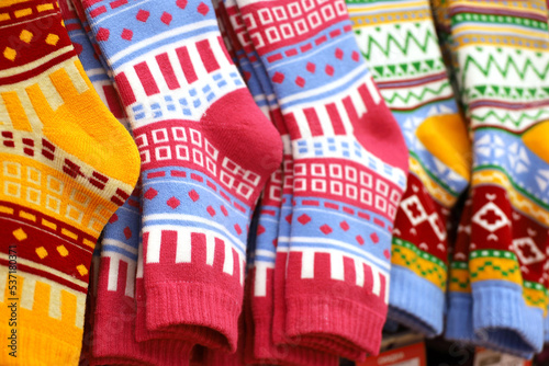 Warm socks with colorful pattern on a store hangers. Outfit and gifts for Christmas holidays