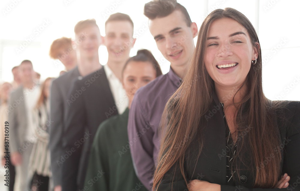 Obraz premium smiling young woman standing in front of a group of diverse young people