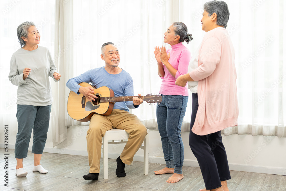 Obraz premium Group of senior people enjoying with activities together with doctor. Elderly people having fun concept. Happy senior playing guitar and singing songs having fun together.