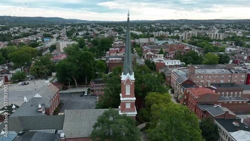 Aerial orbit of church steeple in USA. American city during summer evening overcast sky. photo