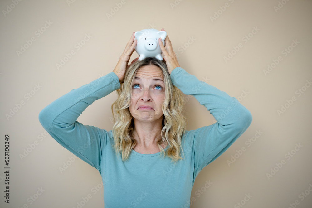 pretty young woman with white piggy bank in front of brown background